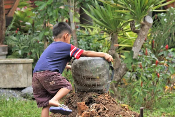Asian Boy Pours Soil Bucket — Stok Foto