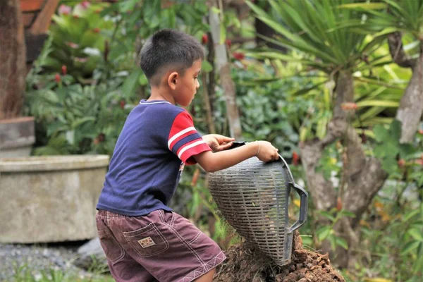 Asian Boy Pours Soil Bucket — ストック写真