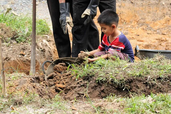 Asian Boy Pours Soil Bucket — Zdjęcie stockowe