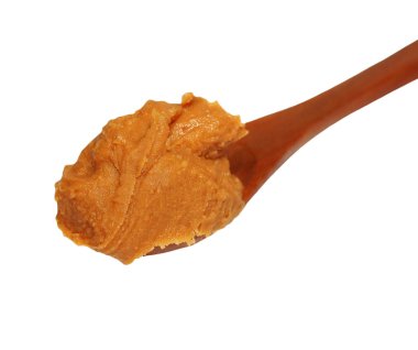 Fıstık ezmesi ile palm yağı, tahta kaşık üzerine beyaz izole