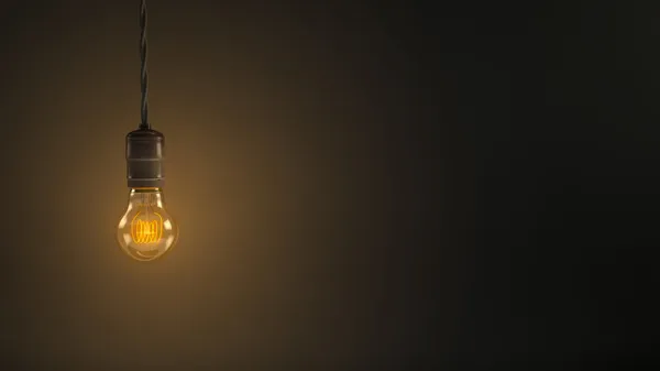 Vintage hanging light bulb over dark background — Stock Photo, Image