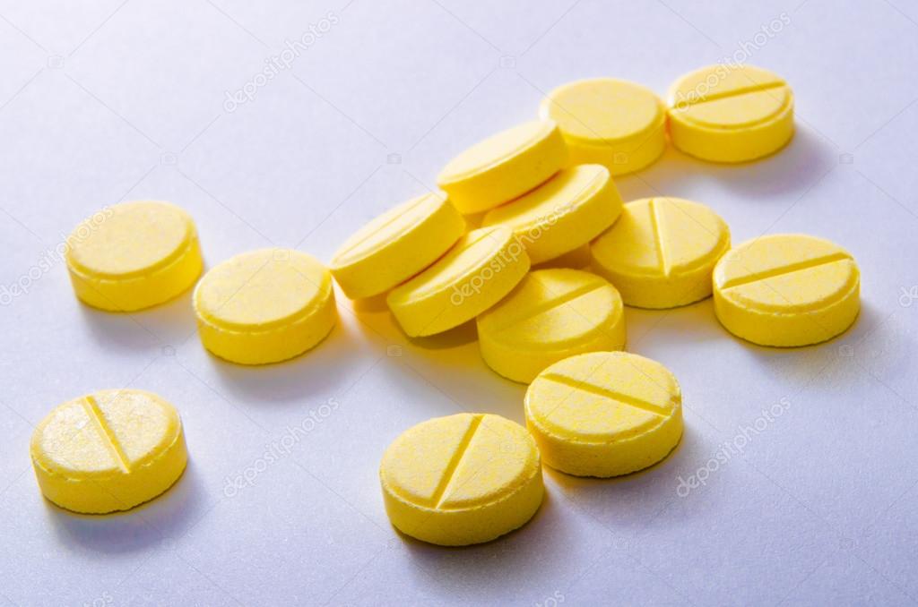 蓝色背景上的黄色药丸– 图库图片