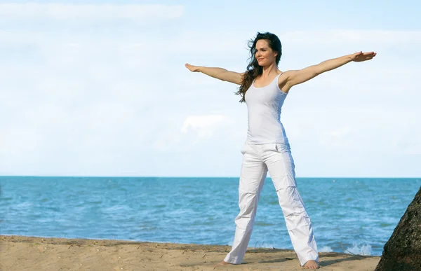 Giovane donna che fa yoga sulla spiaggia — Foto Stock