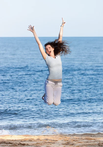 Kvinna hoppa på en strand — Stockfoto