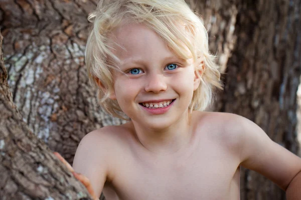 Smiling young boy lying in grass smiling — Stock Photo, Image