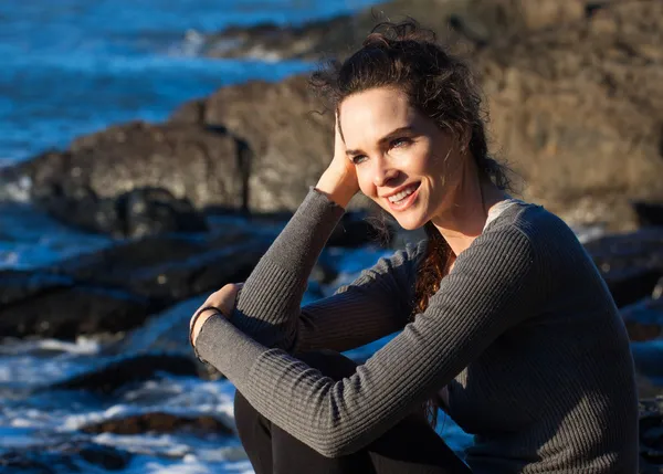 Gelukkige vrouw zitten aan de kust — Stockfoto