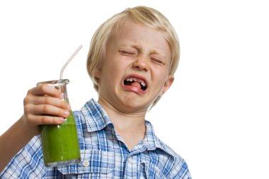 Boy pulling funny face holding green smoothie clipart