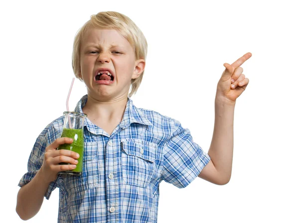 Menino enojado com smoothie verde apontando — Fotografia de Stock