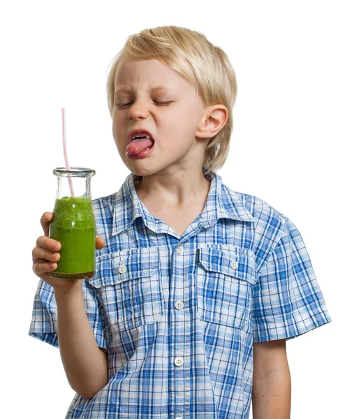 Menino cutucando a língua para fora no smoothie verde — Fotografia de Stock