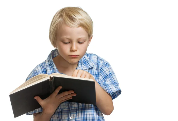 Молодий хлопчик читає товсту книгу . — стокове фото