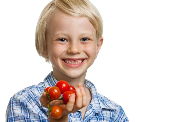 Mignon garçon tenant tas de tomates — Photo