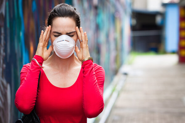 Женщина с головной болью в маске
