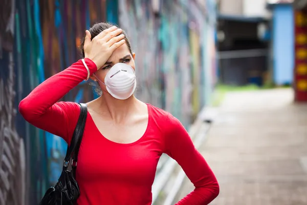 Kadının yüzü maskeli baş ağrısı ile Stok Resim