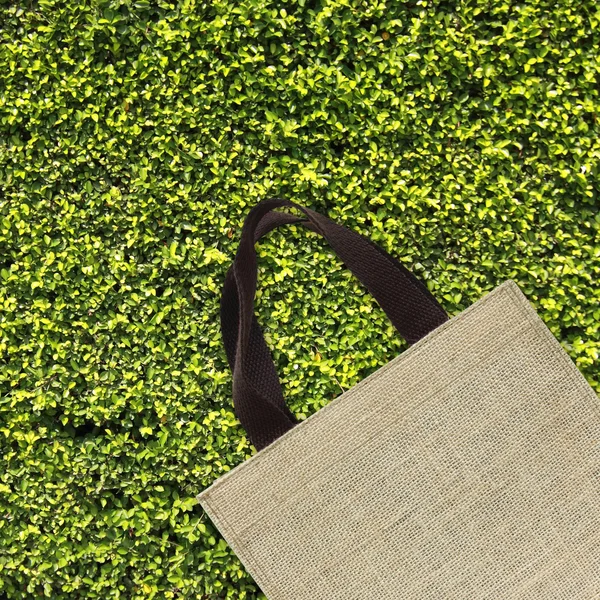 Shopping bag on green leaves