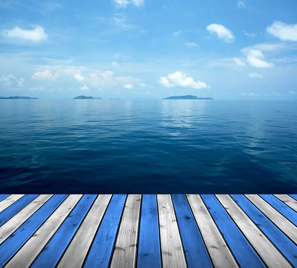Oceano com céu e chão de madeira — Fotografia de Stock