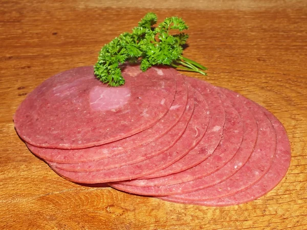 Sliced ​​fresh sausage slices on an oak board — Stock Photo, Image