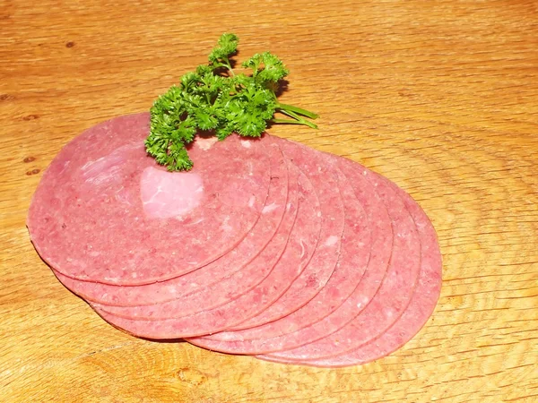 Rodajas de salchichas frescas en rodajas en una tabla de roble —  Fotos de Stock