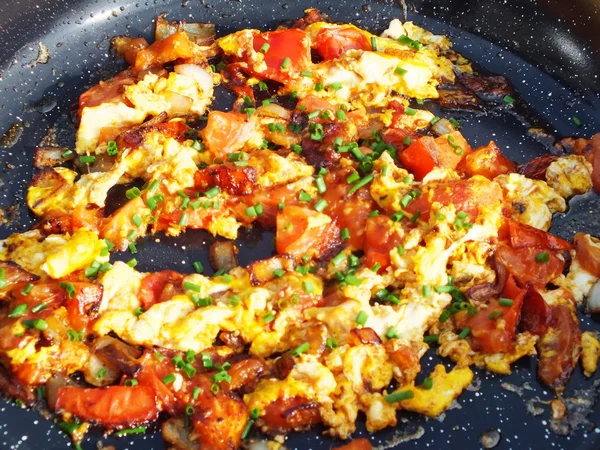 Смажене яйце з помідорами, цибулею на сковороді — стокове фото