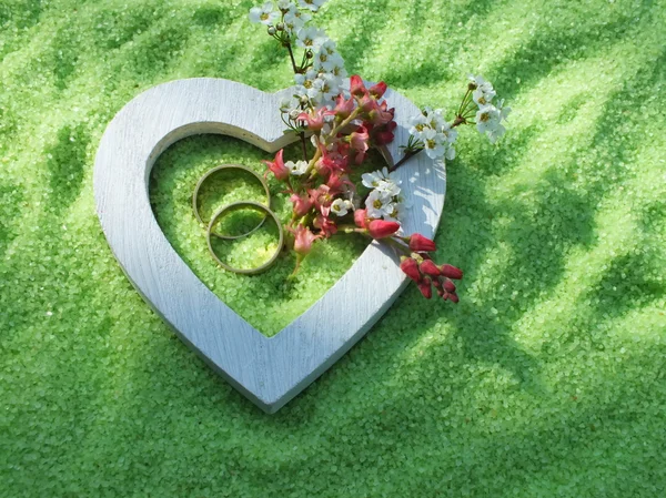 Coeur blanc et anneaux de mariage en bois avec des fleurs délicates en petites pierres — Photo