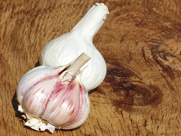 Los dientes de ajo frescos en la tabla de madera del roble — Foto de Stock