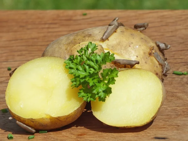 Bio jeunes pommes de terre bouillies au persil sur une planche de chêne — Photo