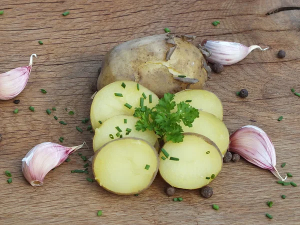 Bio young boiled potatoes with parsley on a oak board — Stock Photo, Image