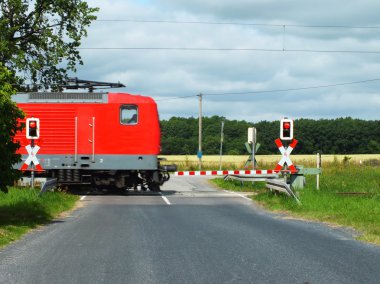 Red railway track a barrier on a road on which country clipart
