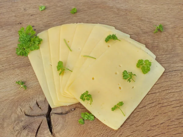 Нарезанный сыр на доске из дуба — стоковое фото