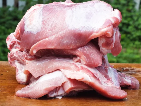 Rohes Schweinefleisch mit Fett auf einem Holzbrett — Stockfoto