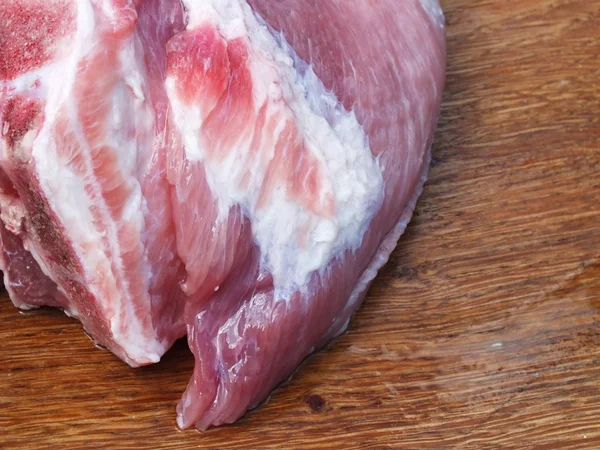 Raw pork with fat on a wooden board — Stock Photo, Image