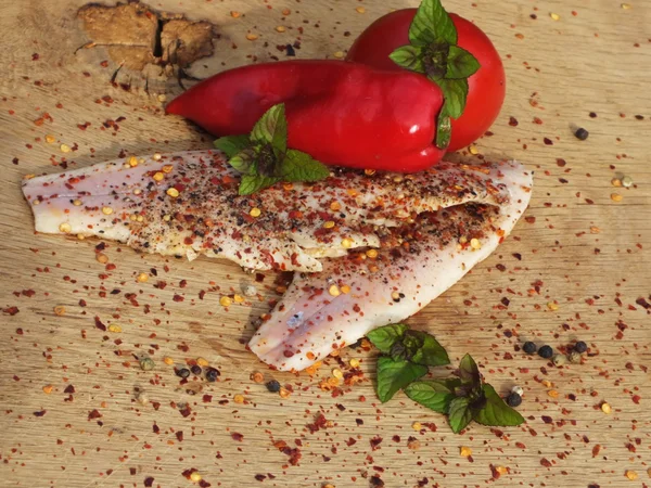 Rökt fisk med peppar och chili på en bädd av ek — Stockfoto