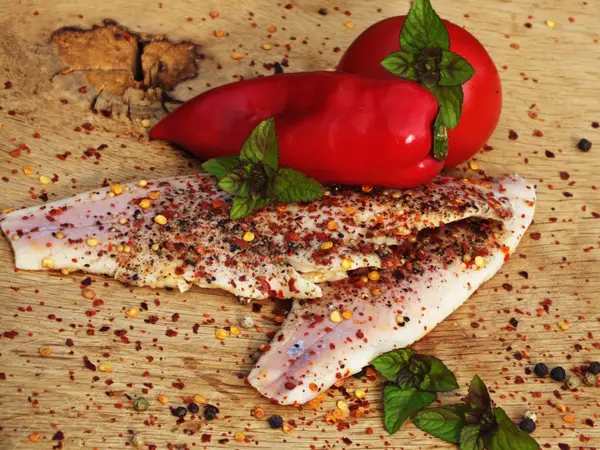 Smoked fish with pepper and chili on a bed of oak — Stock Photo, Image