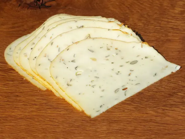 Vers gesneden plakken kaas op een eikenhouten plank — Stockfoto