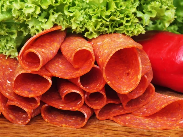Sliced sausage on a board from oak — Stock Photo, Image
