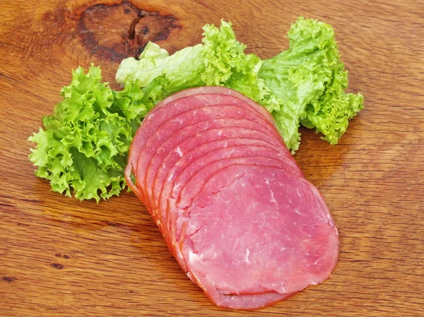 Salsicha cortada em uma tábua de carvalho — Fotografia de Stock
