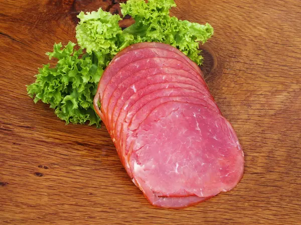 Sliced sausage on a board from oak — Stock Photo, Image