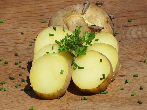 Pommes de terre tranchées sur une planche de chêne — Photo