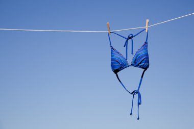 Mavi bikini üst clothesline üzerinde asılı