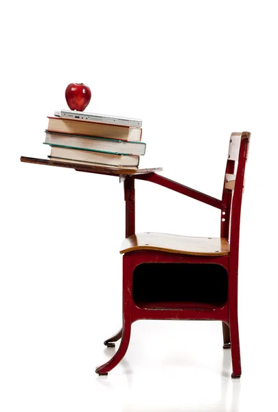 A school desk with books, computer and apple — Stock Photo, Image