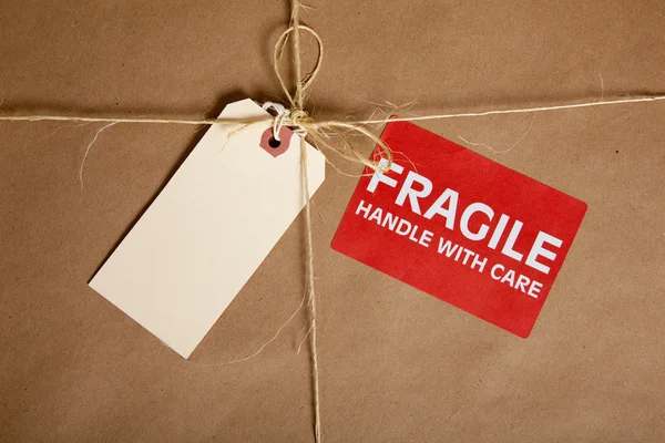 A Shipping box with a blank tag and a Fragile Sticker — Stock Photo, Image