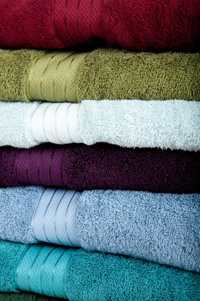 Un fondo hecho de toallas de colores apilados surtidos — Foto de Stock