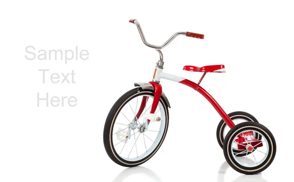 Красный трехколесный велосипед на белом фоне с копировальным пространством — стоковое фото