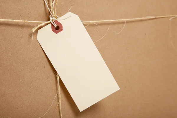A Shipping Box Ties with string with a blank label — Stock Photo, Image