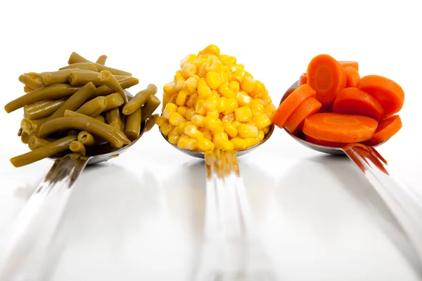 Colheres de cozinha com legumes — Fotografia de Stock