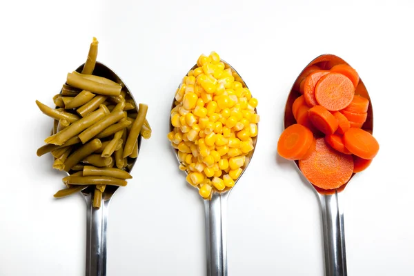 Colheres de cozinha com legumes — Fotografia de Stock