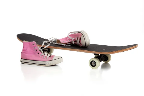 Skateboard en roze sneakers — Stockfoto