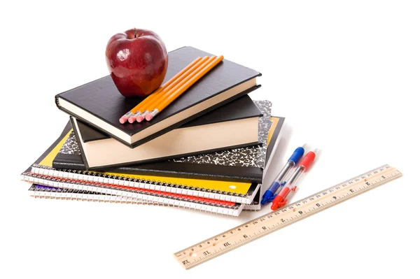 Pomme et fournitures scolaires sur fond blanc — Photo