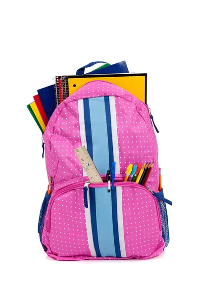 Mochila rosa con útiles escolares sobre fondo blanco — Foto de Stock