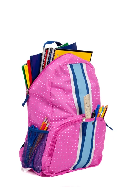 Mochila rosa con útiles escolares sobre fondo blanco — Foto de Stock