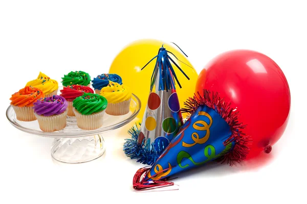 Cupcakes, ballonnen en partij hoeden op een witte achtergrond — Stockfoto